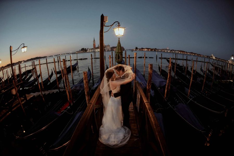 Bride & groom above gondola Venice