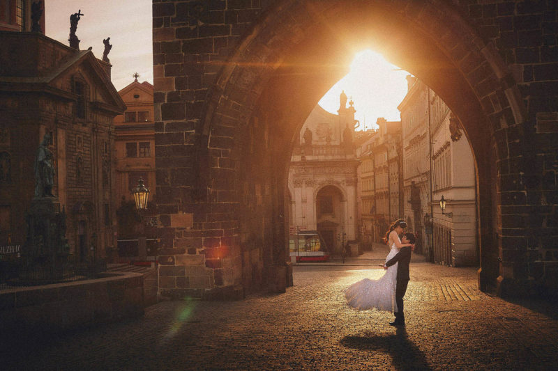 Stylish couples poses: picking up your partner and spinning thm around under the gothic tower atop the Charles Bridge as the sun flares above.