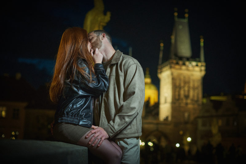 Max and Bryanna share an impromptu kiss atop the historic Charles Bridge after the surprise proposal in Prague.