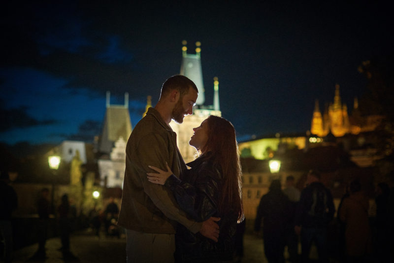 Max and Bryanna embrace atop the Charles Bridge on the evening of their surprise engagement in Prague.